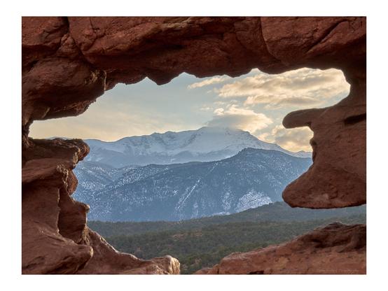 Snow-covered Pikes Peak, seen through the "window" in the Siamese Twins rock formation in Garden of the Gods.