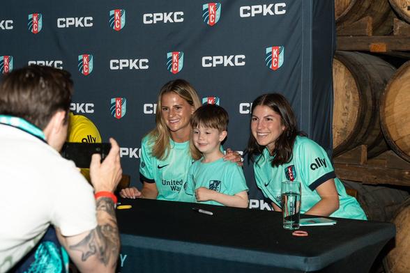 Feist and Rodriguez smiling with a young fan at the event