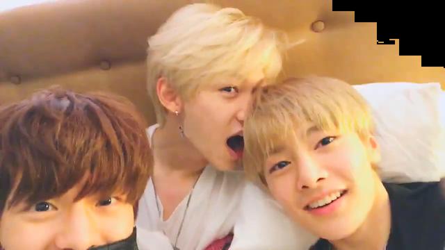 Seungmin, Felix and I.N in I.N's bed, looking at the camera. Felix has his mouth open as though he's attempting to bite I.N's head.