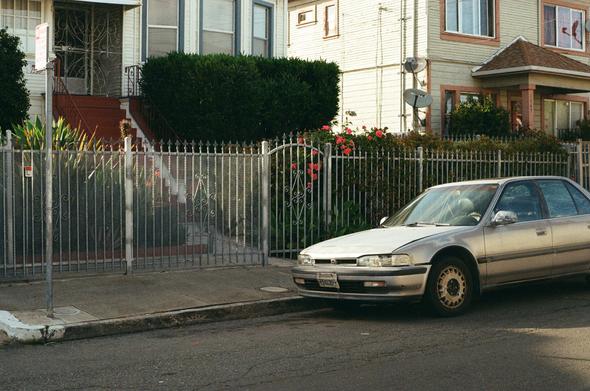 A weathered 1990-91 Honda Accord EX is parked on the street in front of turn of the century Victorian and Edwardian houses