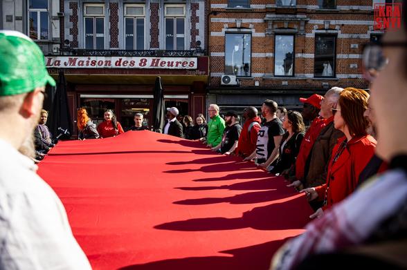 Les manifestants tiennent ensemble symboliquement un triangle rouge géant.