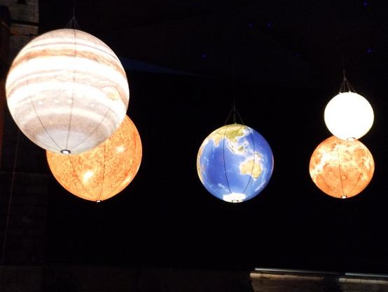 Bunt beleuchtete Lampions als Planeten, einer davon die Erde.