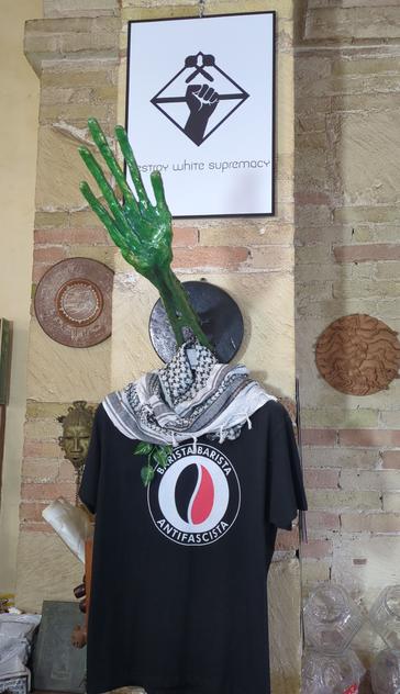 Photograph of a white sign stating "destroy white supremacy" and underneath a black T-shirt with a "Batista Batista antifacista" logo.
