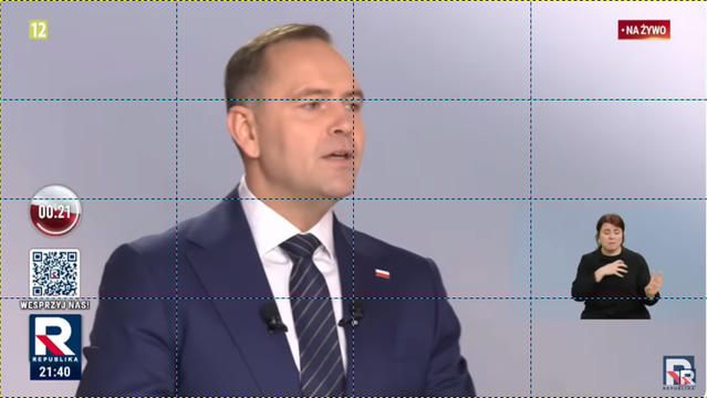 Screen z debaty prezydenckiej 2025 w Republice. W samym centrum jest Nawrocki, tłumaczka PJM w prawym dolnym rogu, ubrana na czarno i tłumacząca na żywo. Obraz jest podzielony  niebieskimi liniami na 32 równe części. Widać, że tłumaczka mieści wysokością w jednym z nich.