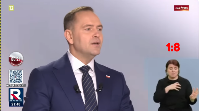 Screen debaty prezydenckiej w Republice 2025. W centrum jest Nawrocki. W prawym dolnym rogu jest tłumaczka powiększona tak by zajmowała 1:8 ekranu.