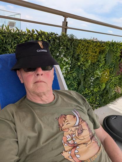 Man on a sun bed in Malta sporting a cupoftea.social t-shirt