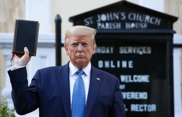 Donald Trump vor einer Kirche, die Bibel in der rechten Hand hochhaltend.