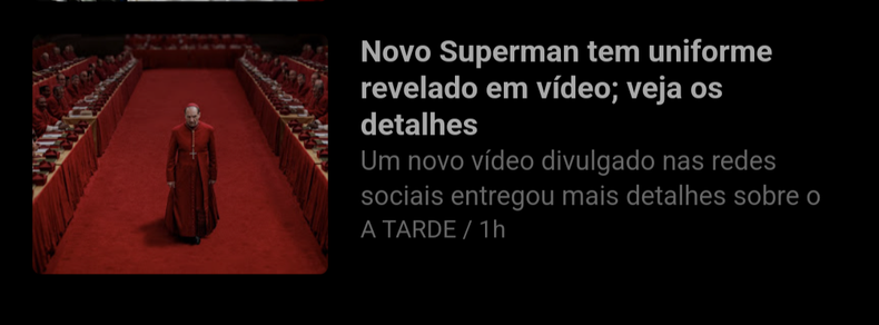 screenshot de uma entrada do meu feed rss. a manchete diz "novo superman tem uniforme revelado em vídeo; veja os detalhes". a imagem mostra uma cena do filme conclave, em que um cardeal trajado em vermelho caminha em uma sala vermelha".