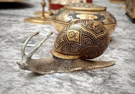 Figura de un caracol con la concha damasquinada.