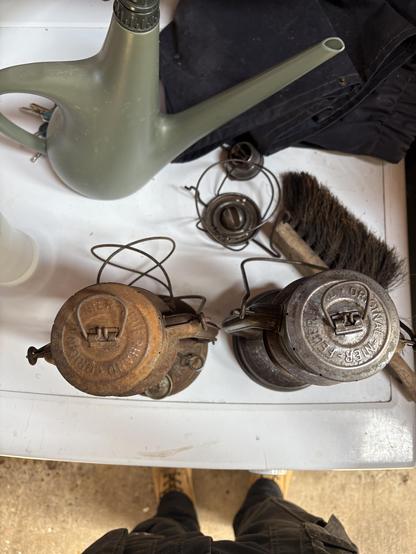 A pair of antique lanterns. The one on the right is undergoing restoration and the one on the left is how it looked before.