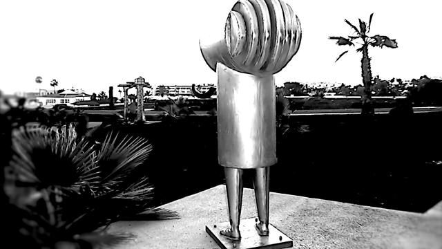 Metallskulptur
Eine Figur aus Metall. Kopf, schmaler Oberkörper und 2 Beine und Füße steht auf einer Steinplatte und schaut in die Ferne.