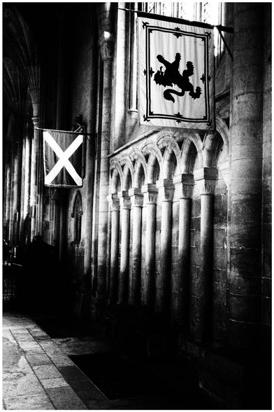 A Scottish saltire and lion rampant hang in Peterborough cathedral over the original grave site of Mary, Queen of Scots. Crunchy monochrome.
