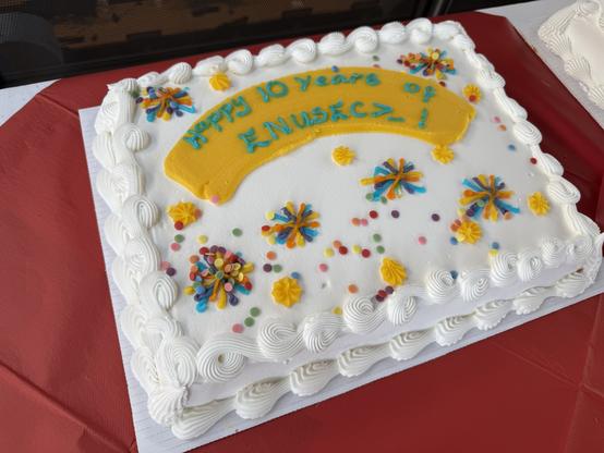 A white square cake that says “Happy 10 years of ENUSEC”