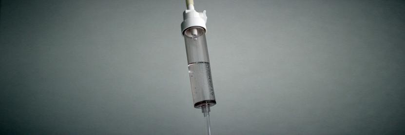 An IV drip in a stark grey room