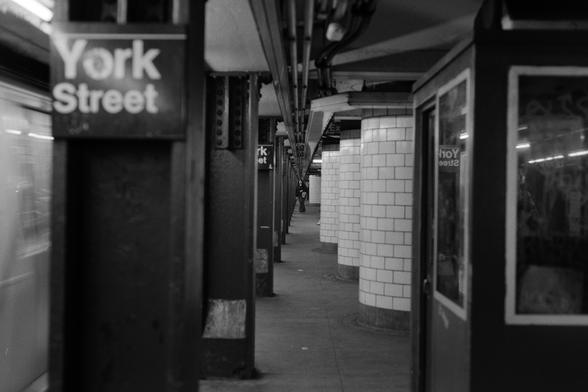 A view down a subway station, a woman standing at the far end