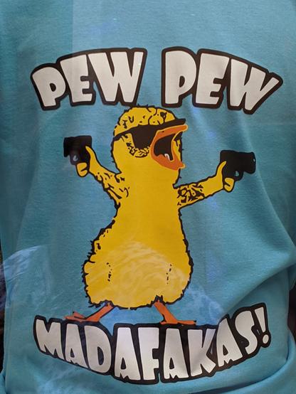 Tshirt print of a little yellow rebel ducky with sunnies on and two guns pulled between the words "pew pew madafakas!"