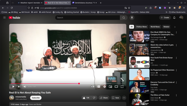 The image shows a YouTube video page with a video playing in the center. The video features four individuals seated at a table with microphones, with a black flag bearing Arabic script in the background. Two individuals are wearing white turbans and traditional attire, while the others are in military-style clothing. The video is titled "Real Is Not About Keeping You Safe" and has 191K views, uploaded by "mismedia" 3 days ago. The video's thumbnail shows a similar scene with armed individuals. The YouTube interface includes a search bar, a list of related videos on the right, and various tabs such as "All," "Politics," and "World News." The video's thumbnail and the flag in the background suggest a connection to a specific group or ideology.

Provided by @altbot, generated privately and locally using Ovis2-8B