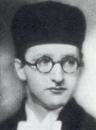 The face of a man in round-framed glasses and a tall straight hat.