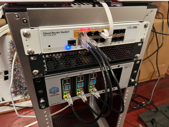 A minirack holding a Mikrotik CRS112-8P-4S-IN switch with three Raspberry Pis connected to it and drawing power from it via Power-over-Ethernet.  The Pis are in a 2U shelf.