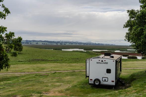 A photo of a landscape with an RV in the lower corner overlooking a beautiful view.