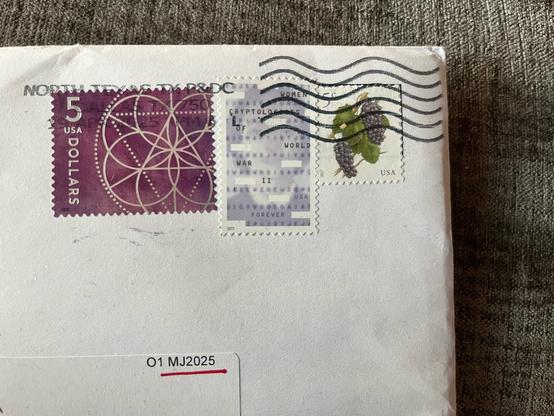 Stamps on an envelope sent by the Cryptogram magazine. The center stamp is a commemorative stamp honoring women cryptologists during World War 2.