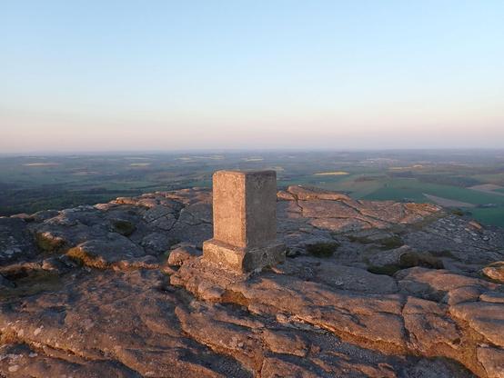 Photo of Bennachie trigpoint on Mither Tap. Low evening sunshine and a fine view of Aberdeenshire down below from one of the tops of Bennachie. The trig is a bit unusual as it's an untapered block shaped pillar without a flush bracket.