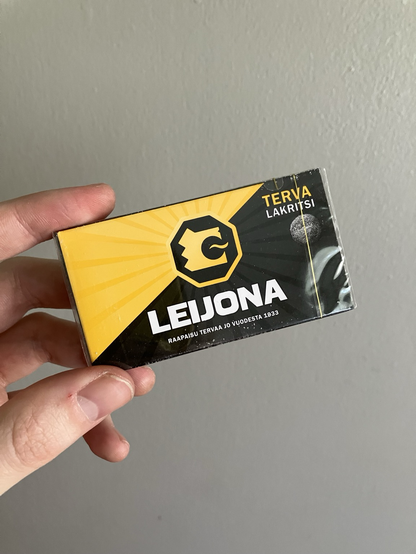 Kädessä Terva Leijona -makeisaski.