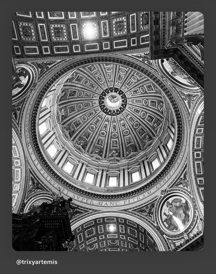 Black and white photo of the ornate interior moldings and architectural details of St. Peter’s Basilica’s dome, highlighting intricate craftsmanship in light and shadow.