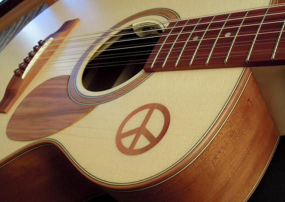 nahaufnahme einer 12saitigen gitarre mit peace-zeichen auf der decke