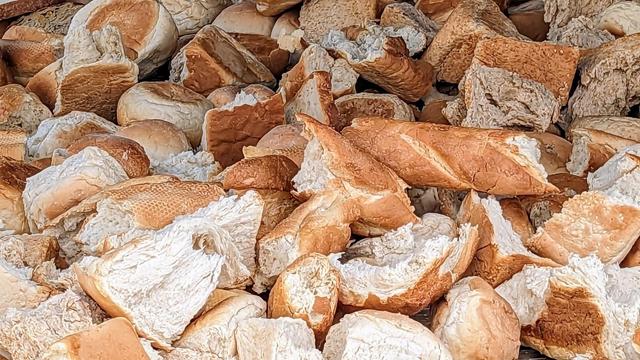 A pile of broken pieces of bread and rolls is scattered in a heap.