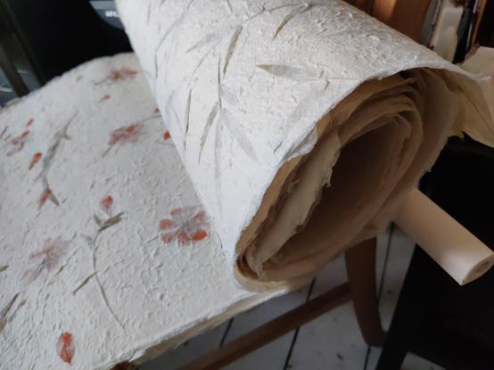 a roll / some sheets of calligraphy paper, flower/plant design