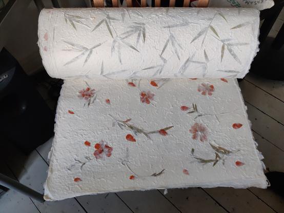 a roll / some sheets of calligraphy paper, flower/plant design