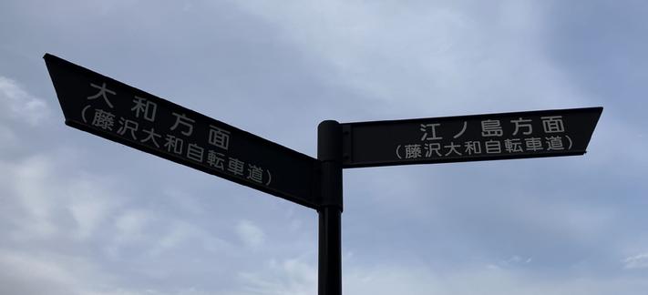 A sign on the bike path. North to Yamato and South to Enoshima.