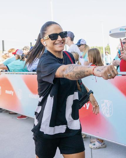 Close up of Debinha arriving at the stadium and holding out a fist bump