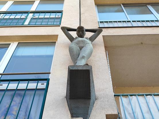 sculpture of a naked woman on a facade of the apartments building