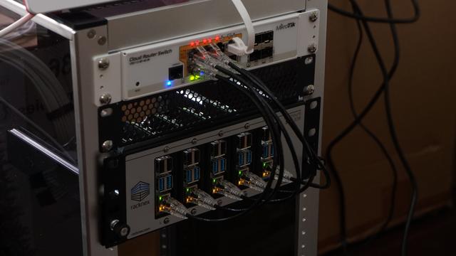 Five Raspberry Pis in a 2U shelf being powered by a PoE switch in a minirack.