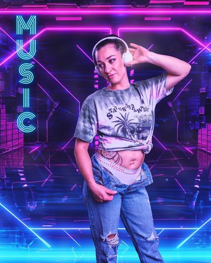 The image shows a person wearing headphones, a tie-dye shirt, and ripped jeans. They have a tattoo on their torso and are standing in a neon-lit environment with futuristic and geometric designs. The word "MUSIC" is displayed on the left side of the image in a bright, illuminated font. Valokuvaaja Lappeenranta Kuvaajankulma