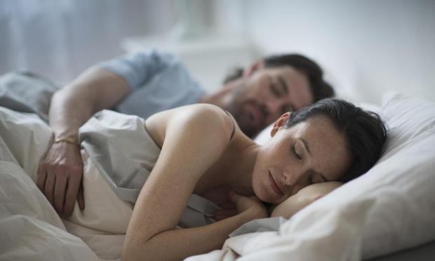 Una pareja durmiendo abrazada en la cama (Getty Images/Tetra images RF)