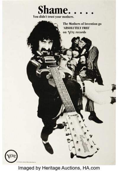 Black and white poster ad for the Mother's of Invention record "Absolutely Free" on Verve records. Frank Zappa, standing, holds his guitar under his chin pointing at us. The balance of the Mothers are huddled in a heap on the floor.