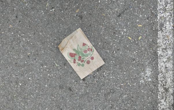 braune bedruckte Packpapiertüte auf einer Asphaltbahn