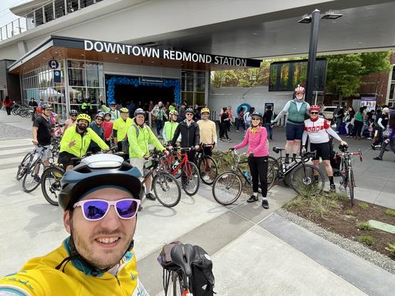 Group selfie with a bunch of cyclists standing in front of the Downtown Redmond light rail station