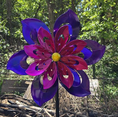 A piece of metal wind art in purple and pink.