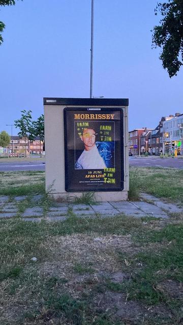 reclame bord van zelfde artiest op huisje . kruispunt en huizen op de achtergrond, blauwe schemer lucht. 3x in geel maai me niet gesprayed (in spiegelbeeld / stencil verkeerd om)