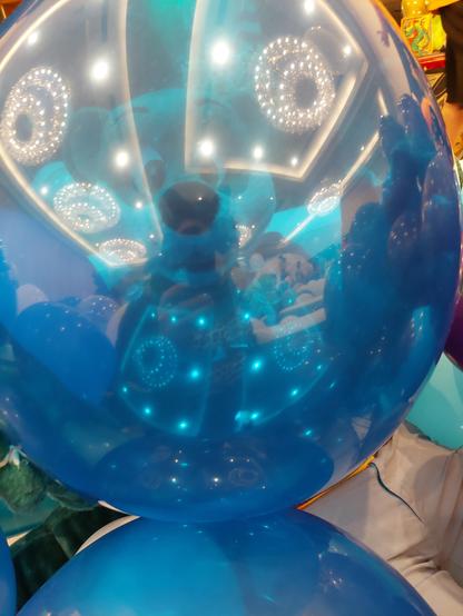 A photo taken through a mostly transparent blue balloon of my husband in his partial otter suit