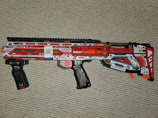 A scifi esque bullpup "nerf" blaster in red and white coloring. Xuru brand X-Shot Longshot
