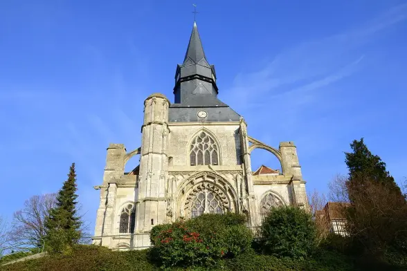 The image depicts a church or a religious building with a distinctive architectural style. It features a tall steeple, pointed arches, and decorative elements typical of Gothic or neo-Gothic architecture. The structure appears to be set against a clear blue sky and is surrounded by greenery, including trees and shrubs.

Image Credits: Wikimedia / JmDeBovet / CC BY-SA 3.0