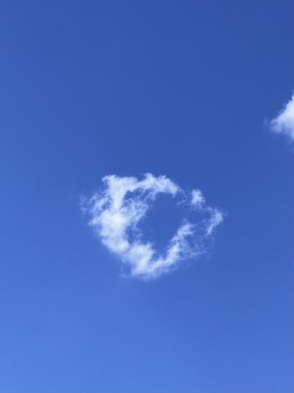 ein kleiner wolkenring vor blauem himmel