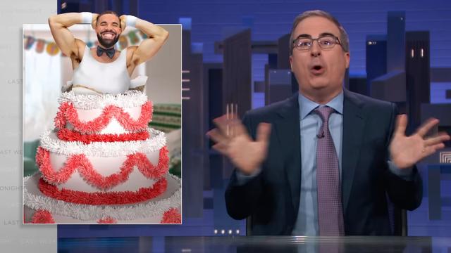Screenshot of ‘Last Week Tonight’ with John Oliver talking next to an image of Drake, dressed like a male stripper complete with bowtie, grinning as he jumps out of a giant fuzzy cake
