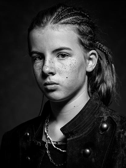 Studioportrait eines ernst in die Kamera schauenden 10jährigen Mädchens