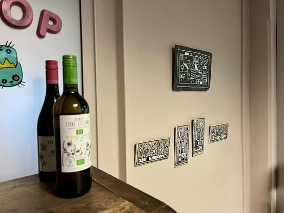 Bottles of wine in front of artwork